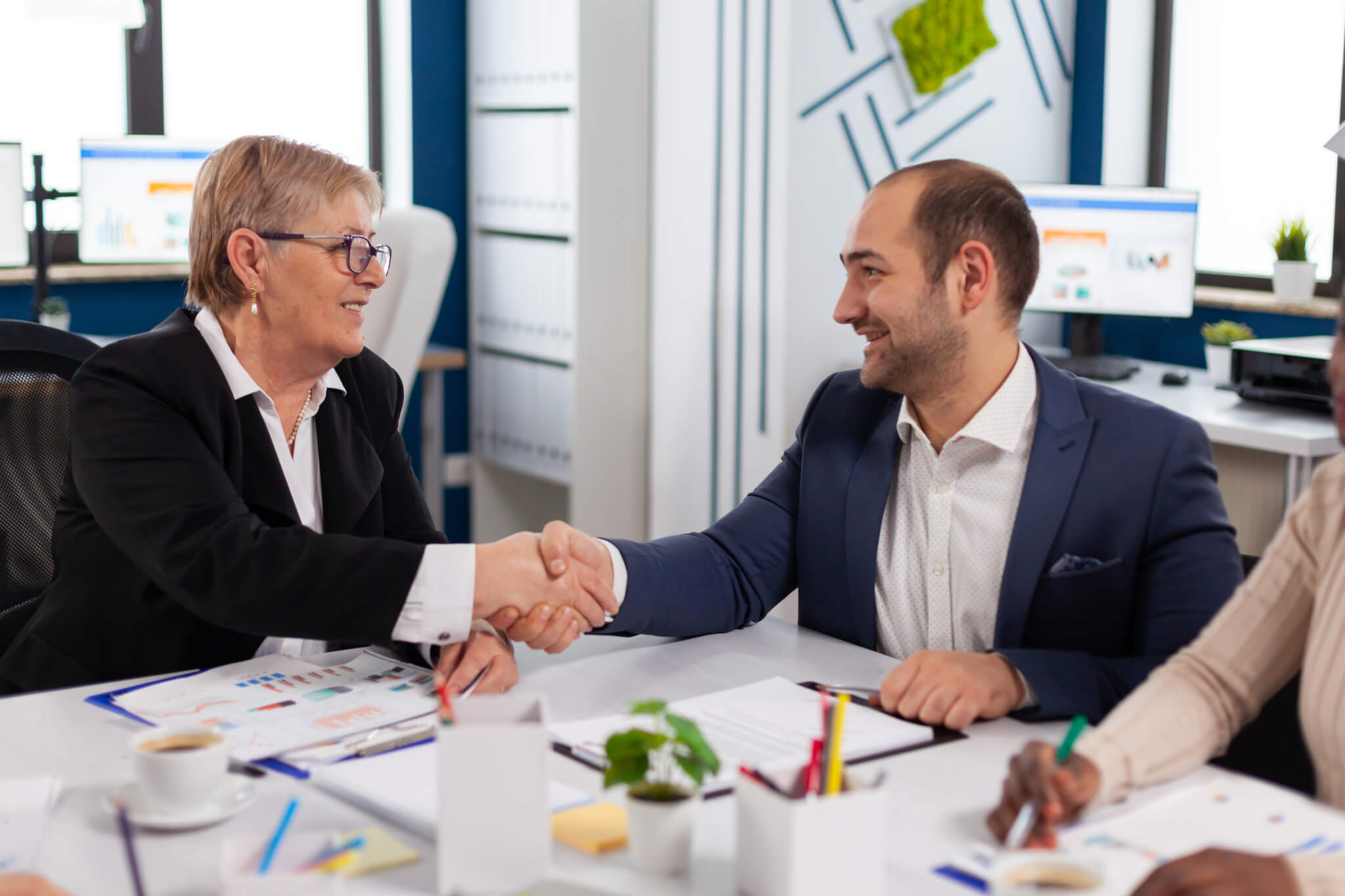 HOA board leaders shaking hands during a professional meeting.