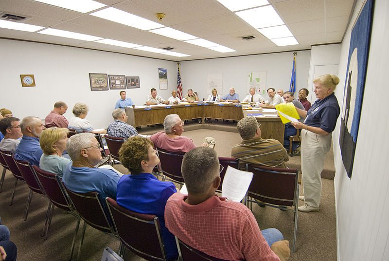 Florida homeowners association board members sitting around a conference table reviewing investment options, vendor contracts and major project plans.
